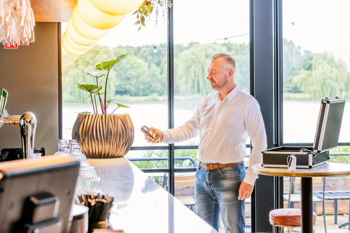 Medewerker van EasyCulti meet met een meetinstrument het licht en de luchtvochtigheid in een kantoorruimte